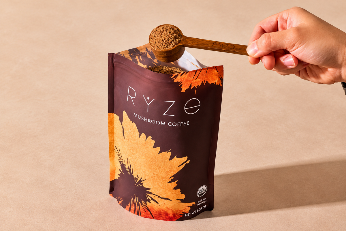 Ryze Mushroom Coffee package with a hand scooping out coffee powder.